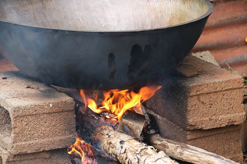 Burning wood creates a hot fire and live coal for cooking.