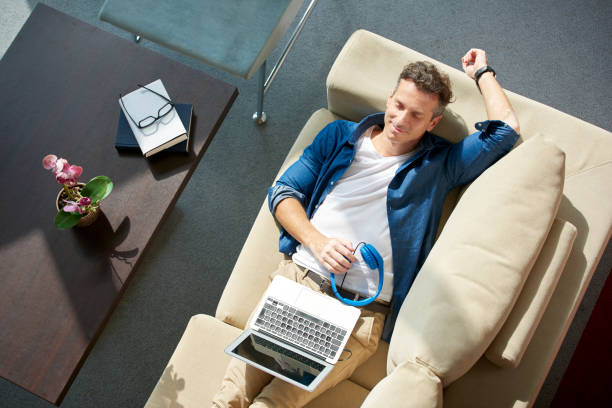istock Relaxed man on couch with laptop 639350206