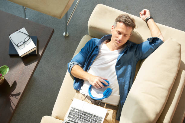 istock Relaxed man on couch with laptop 639350806
