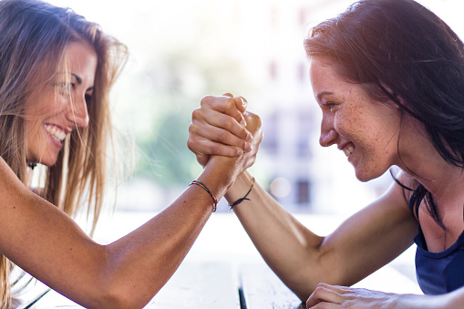 Two girls playing arm wrestling outdoor