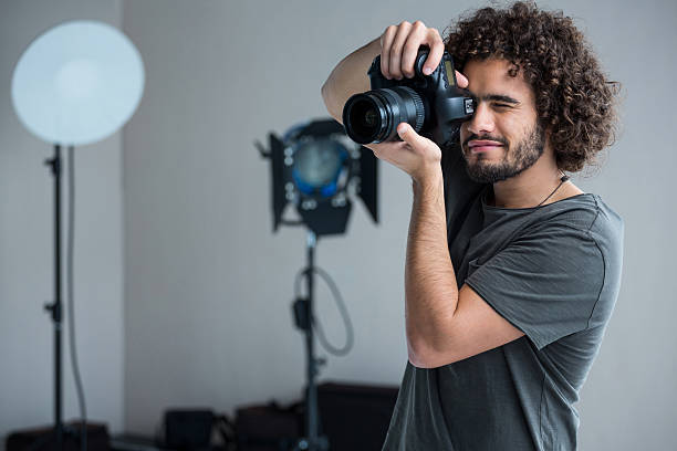 istock Happy male photographer with digital camera in studio 639356500