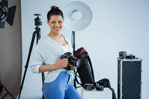 istock Happy female photographer standing in studio 639357472