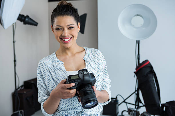 istock Happy female photographer standing in studio 639357592