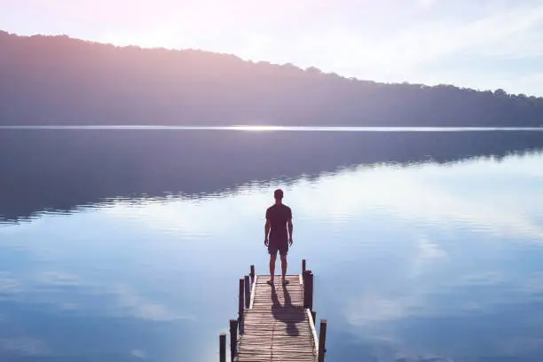 Photo of human strength or psychology concept, man standing on pier