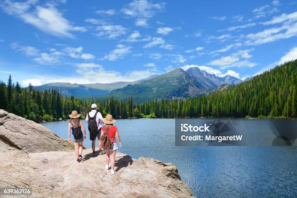 People Standing On Top Of Mountain Looking At Beautiful Landscape Stock Photo - Download Image Now