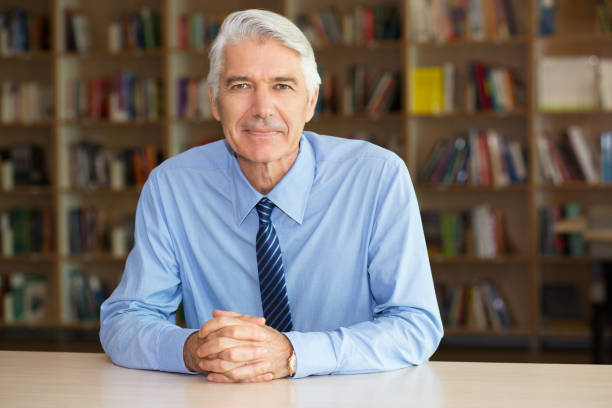 istock Confident senior businessman sitting in library 639363926