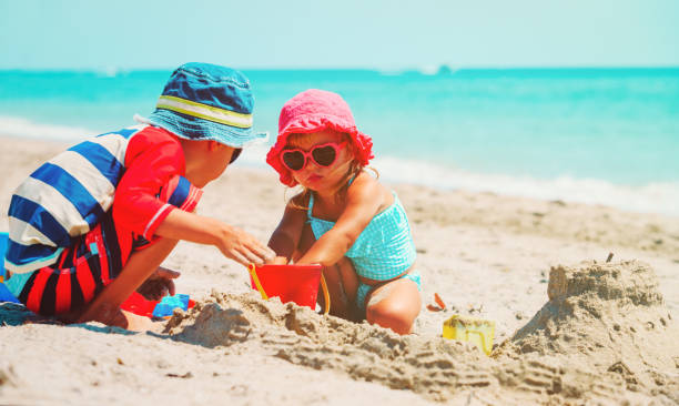istock kids play with sand on summer beach 639365502