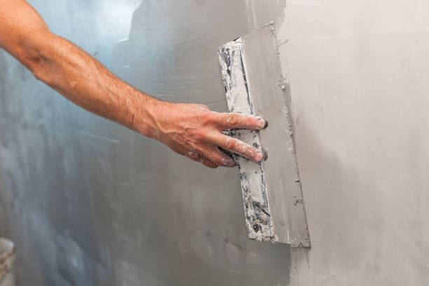 istock Man hand with trowel plastering a wall 639367972