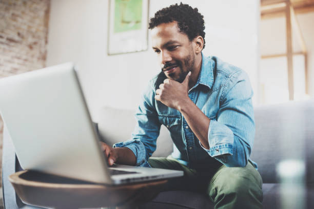 istock Smiling young African man making video call with friends while 639370212