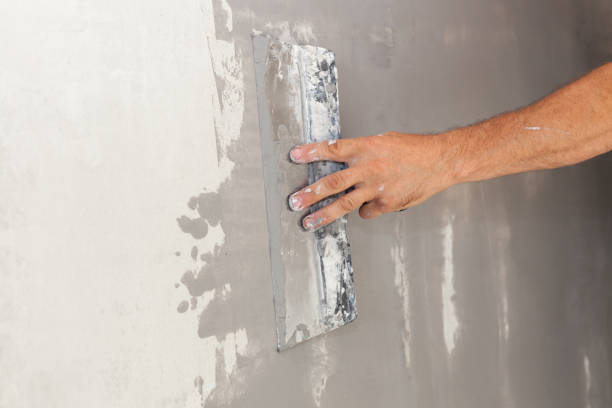 istock Repairman hand plastering a wall with putty knife or spatula 639371368