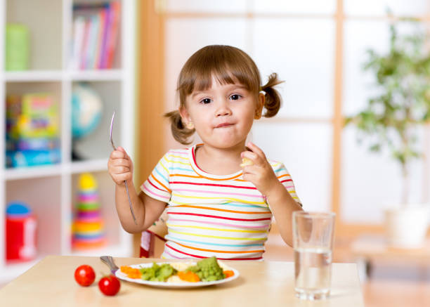 istock Funny little girl has dinner in kindergarten 639374716