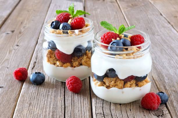 istock Blueberry, raspberry parfaits in mason jars on rustic wood 639375738