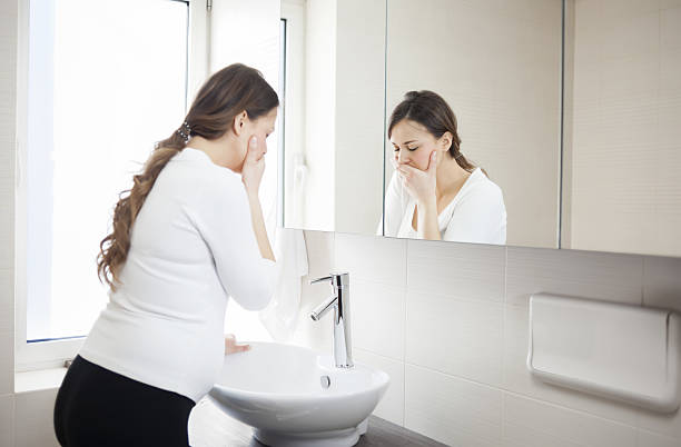 Morning sickness Young Pregnant Woman Suffering With Morning Sickness In Bathroom nausea photos stock pictures, royalty-free photos & images
