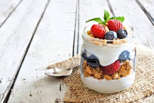 istock Blueberry, raspberry parfait in mason jar on rustic white wood 639376080
