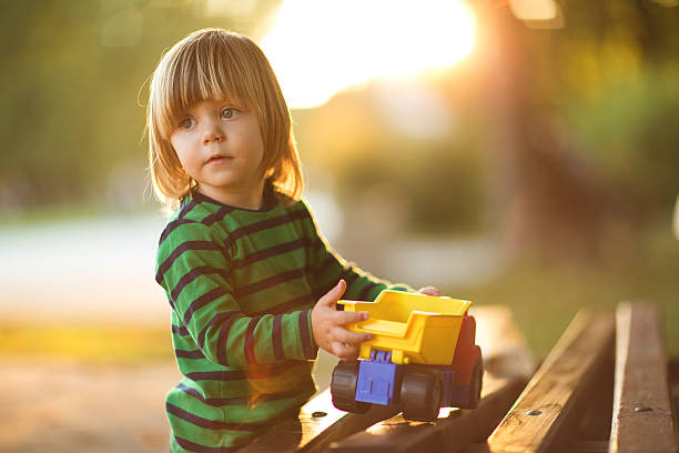 little boy und spielzeug - child playground small toy stock-fotos und bilder