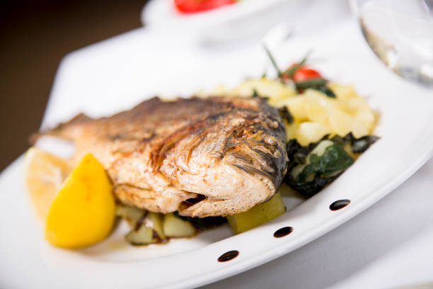 istock Fresh cooked sea bream fish with potato and lemon. 639376632