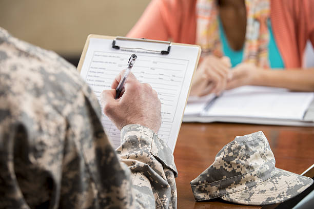 istock Military veteran completes paperwork for psychiatric session 639382510