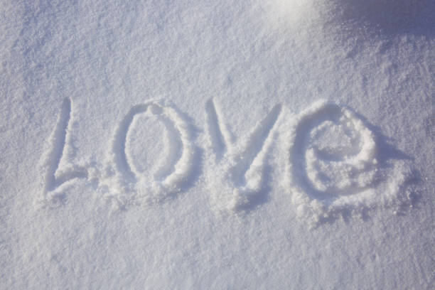 Valentines day background. Love word written in the snow.