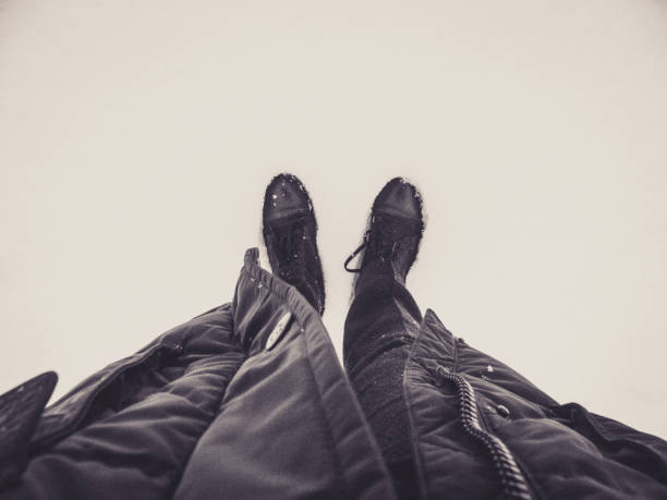 Casually dressed man standing in the snow first person view.