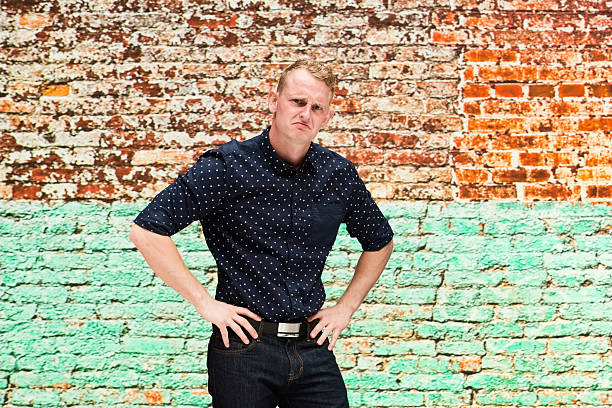 istock Man in front of brick wall and looking sad 639388842