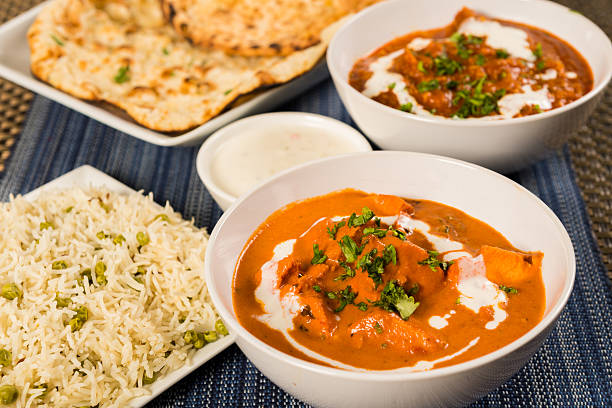 Authentic Indian Food Butter chicken curry, lamb vindaloo, basmati rice, nan bread and yoghurt raita curry stock pictures, royalty-free photos & images