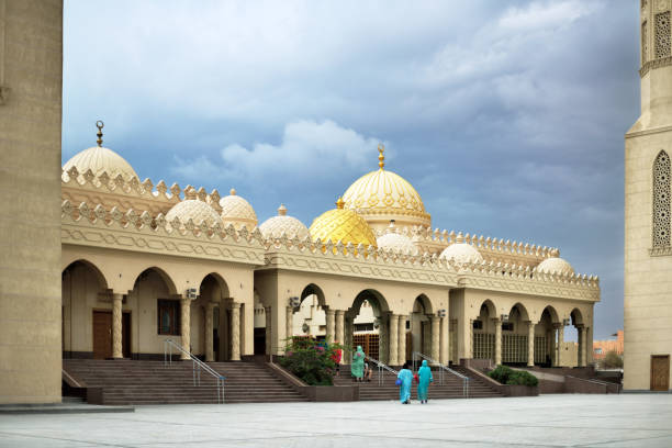 мусульманская мечеть с двумя минаретами пасмурная погода, женщины собираются - arabia architecture asia rear view стоковые фото и изображения