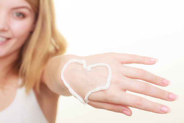 istock Cream on woman hand, heart shape 639393750