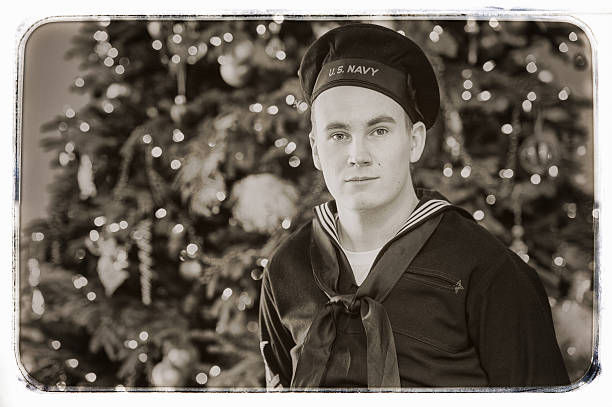 WWII US Navy Sailor Home For the Holidays WWII US Navy Sailor home for the holidays.  He is dressed in an authentic uniform for the period.  Aged photo.  Vintage Style. world war ii photos stock pictures, royalty-free photos & images