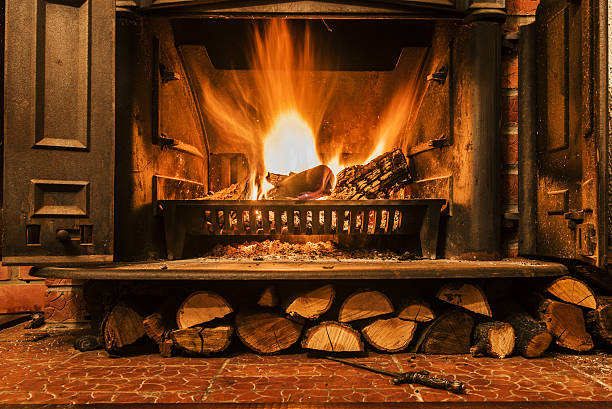 Roaring fire in an arched stone fireplace Roaring fire in an arched stone fireplace, Cozy blazing fire in fireplace brightly lit winter season rock stock pictures, royalty-free photos & images