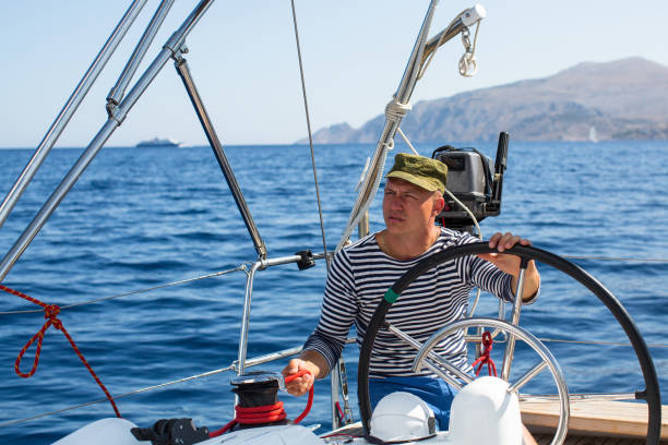 istock Man at the helm sail boat 639398464