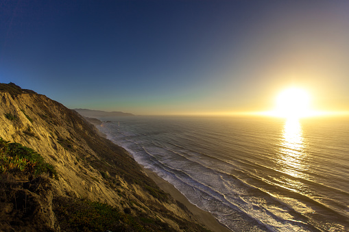 The sun setting over the ocean, from the cliffs near the city of Pacifica, California.
