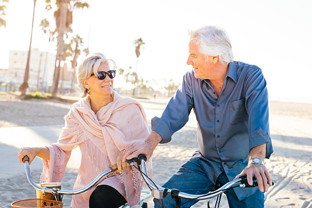 노인을위한 좋은 휴가 - senior couple cycling beach bicycle 뉴스 사진 이미지