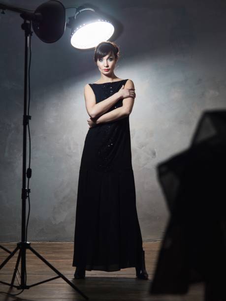 istock Young girl in evening dresses on grey wall. 639404272