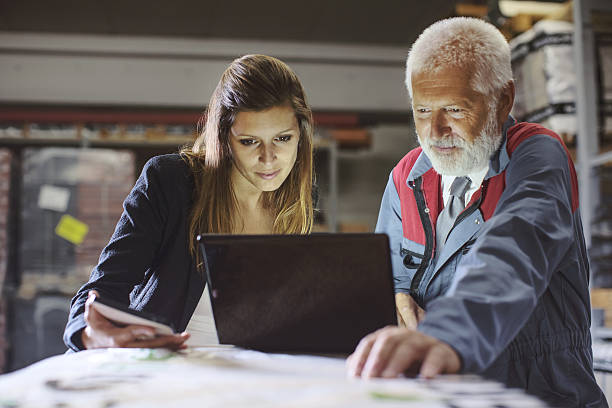 istock Businesswoman and warehouse worker using laptop 639406324