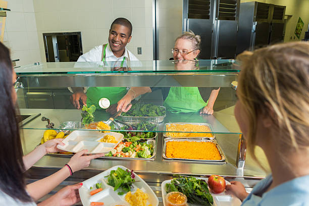 diverse cafeteria works serve high school students - tray lunch education food imagens e fotografias de stock