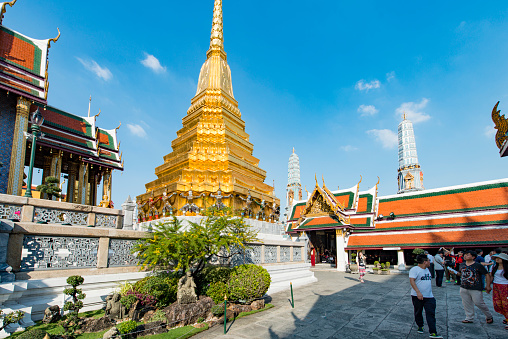 Bangkok, Thailand - December 17, 2016: Tourists visiting Wat Phra Kaew and Grand Palace in Bangkok, Thailand, during a sunny day.