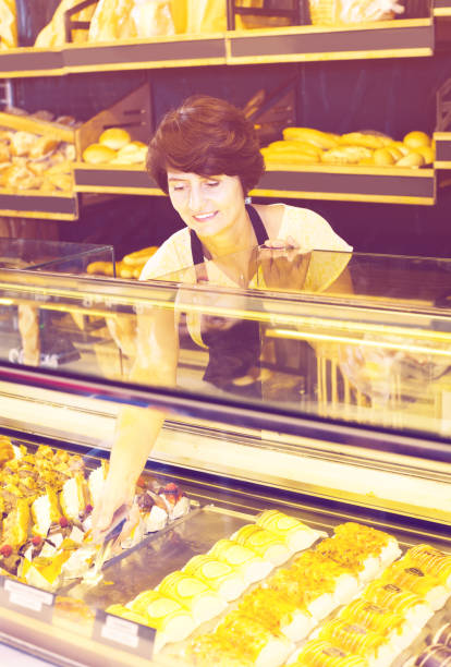 istock female baker offering fresh pastry 639413008