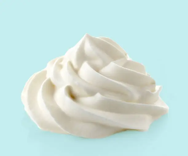 Photo of whipped cream on blue background