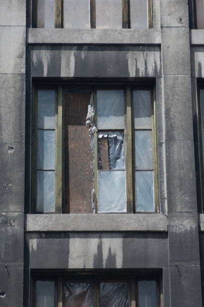 Abandoned building, neglected and vandalised with broken windows and boarded up windows in Montreal, Canada.