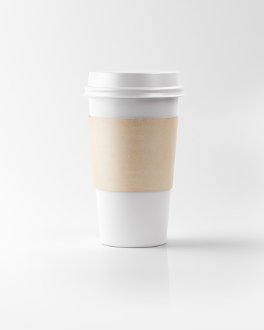 A white colored generic paper insulated coffee cup with lid and cardboard sleeve. Isolated on a white reflective surface. Lit from upper left corner and casting soft shadows on the ground. Clipping path for coffee cup is included.
