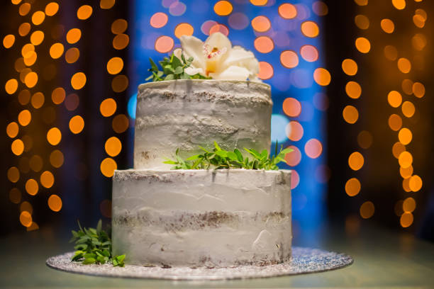 istock Split-level wedding cake with natural flowers on bokeh background 639425380