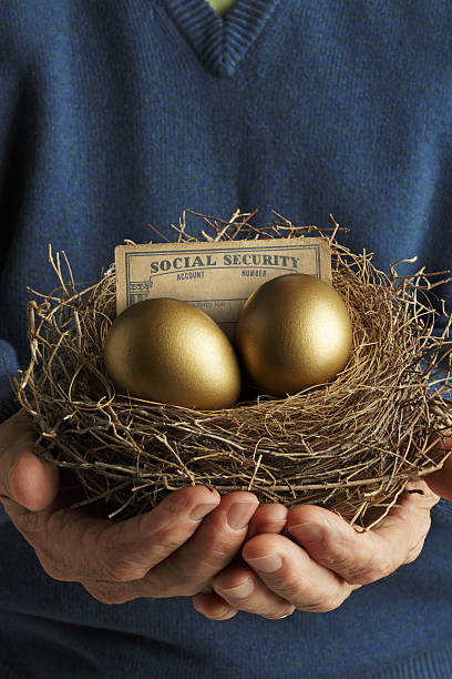 istock Man Holding Nest With Golden Eggs And Social Security Card 639428350