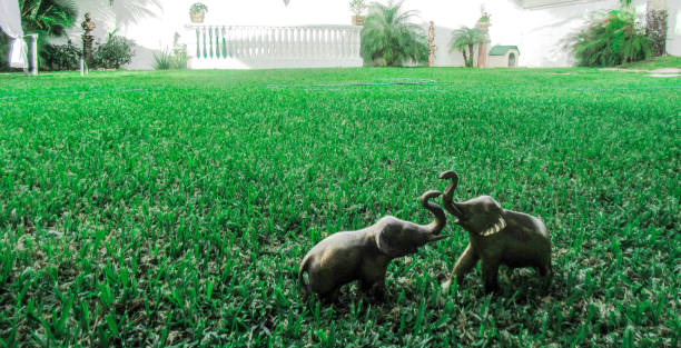 Toy elephant in tall grass. Horizontal.