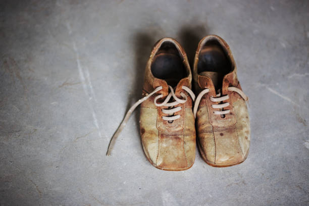 istock Old brown grunge boots on grey cement background 639433384