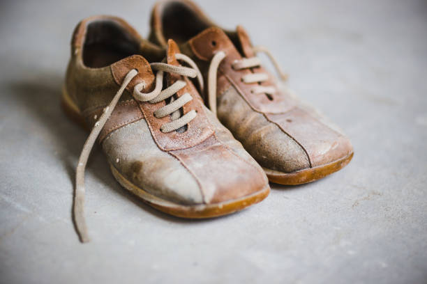 istock Old brown grunge boots on grey cement background 639433438