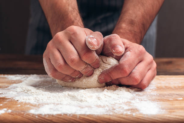 istock Male hands kneading dough close-up 639433678
