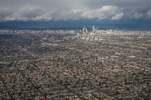 An aerial view of downtown Los Angeles taken after a recent rainfall in January of 2017.  Low cloud coverage blocks the view of the Hollywood hills.  Image is taken above the South Los Angeles, Inglewood, Vermont Harbor,  Hyde Park neighborhoods. 