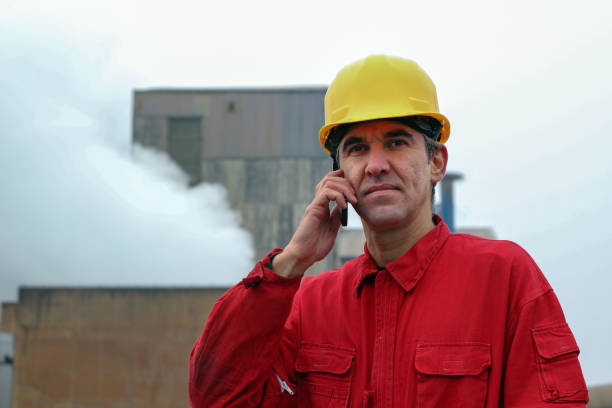 istock Worker Using Smart Phone With Factory in the Background 639438944