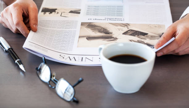 istock Woman reading newspaper on table 639441928