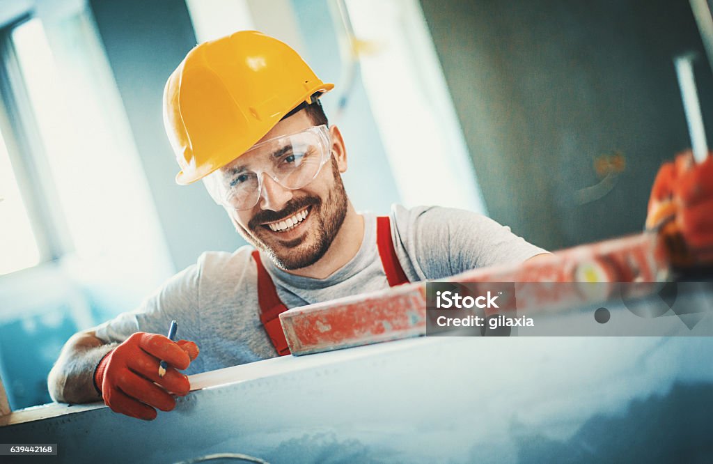 Cheerful construction worker. - Royaltyfri Reparatör Bildbanksbilder